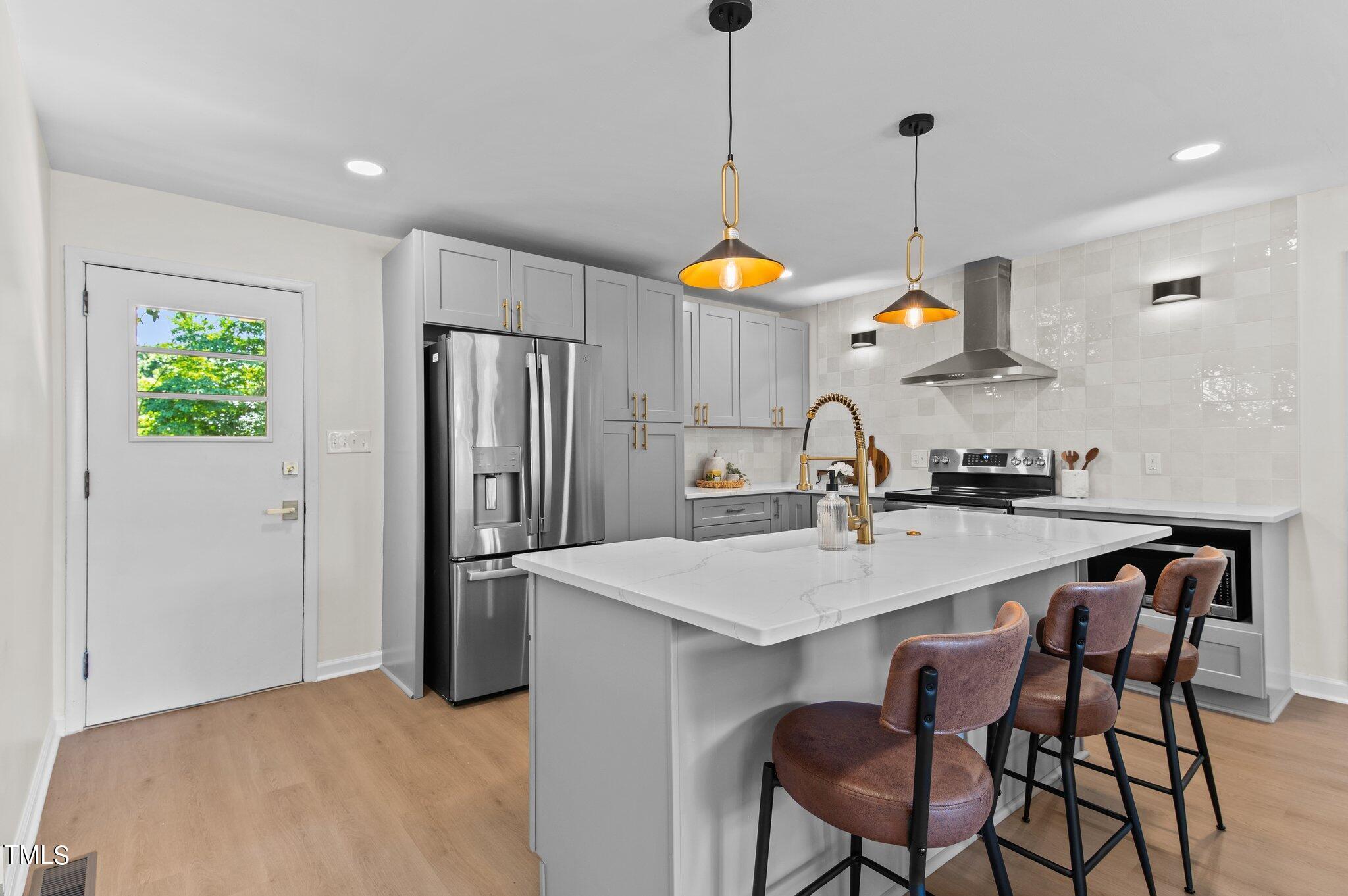 405 Roxanne Drive Raleigh, NC 27603 - Photo 12 of 48 a kitchen with stainless steel appliances granite countertop a sink a stove a refrigerator and island