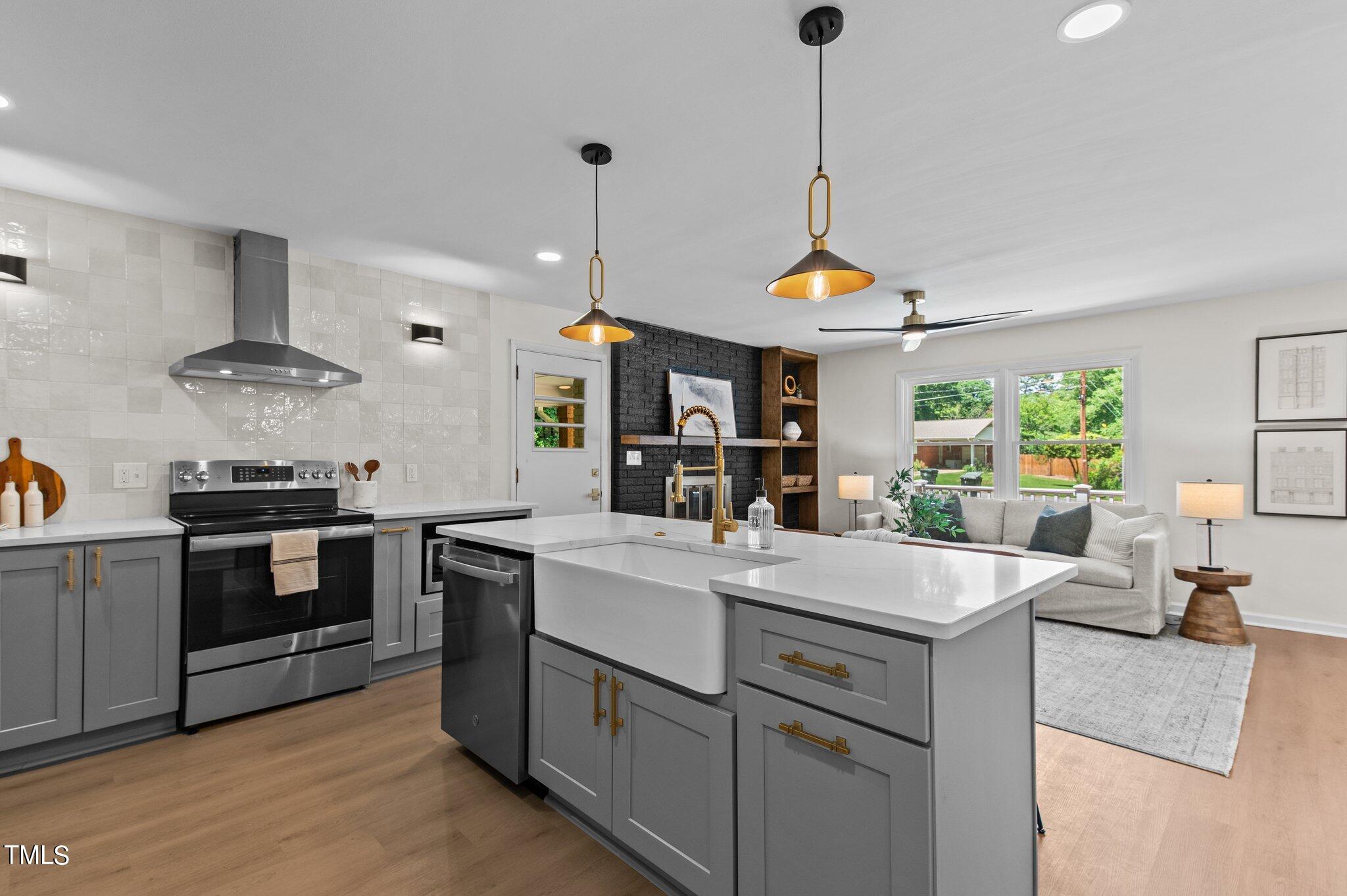 405 Roxanne Drive Raleigh, NC 27603 - Photo 14 of 48 a kitchen with kitchen island granite countertop a stove a sink a center island and couches
