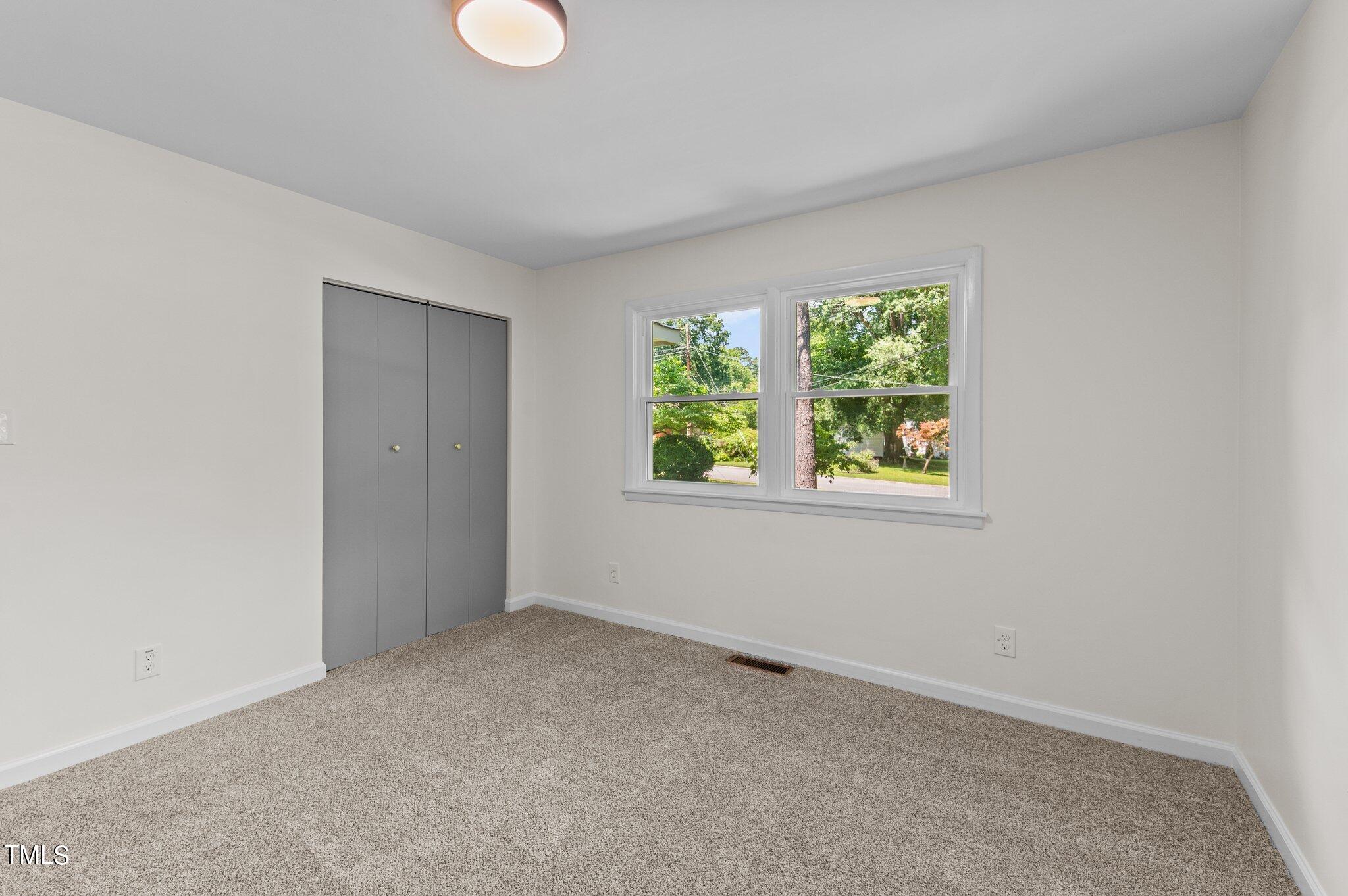 405 Roxanne Drive Raleigh, NC 27603 - Photo 26 of 48 an empty room with a window and a ceiling fan