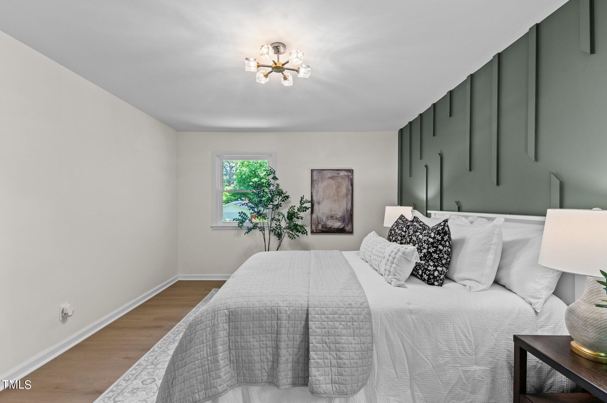 405 Roxanne Drive Raleigh, NC 27603 - Photo 31 of 48 a bedroom with a bed and a potted plant