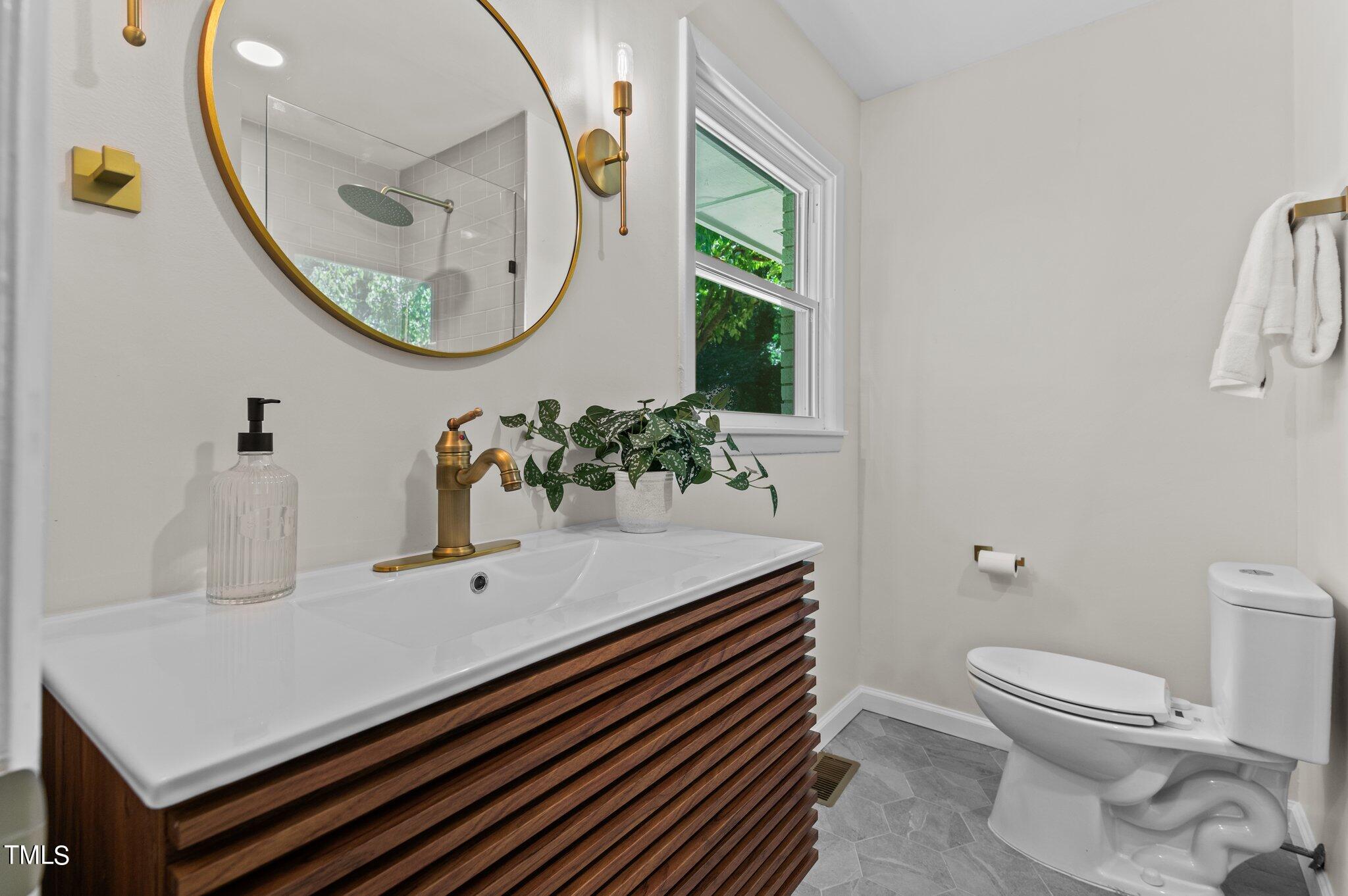 405 Roxanne Drive Raleigh, NC 27603 - Photo 32 of 48 a bathroom with a sink a mirror and a toilet