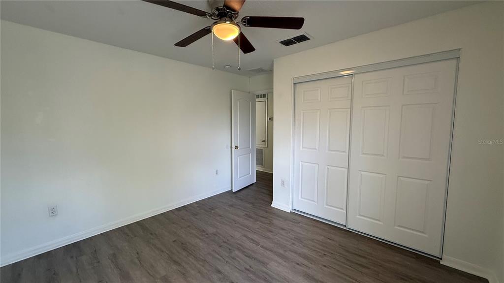 4484 Philadelphia Circle Kissimmee, FL 34746 - Photo 15 of 56 an empty room with wooden floor closet and windows fan