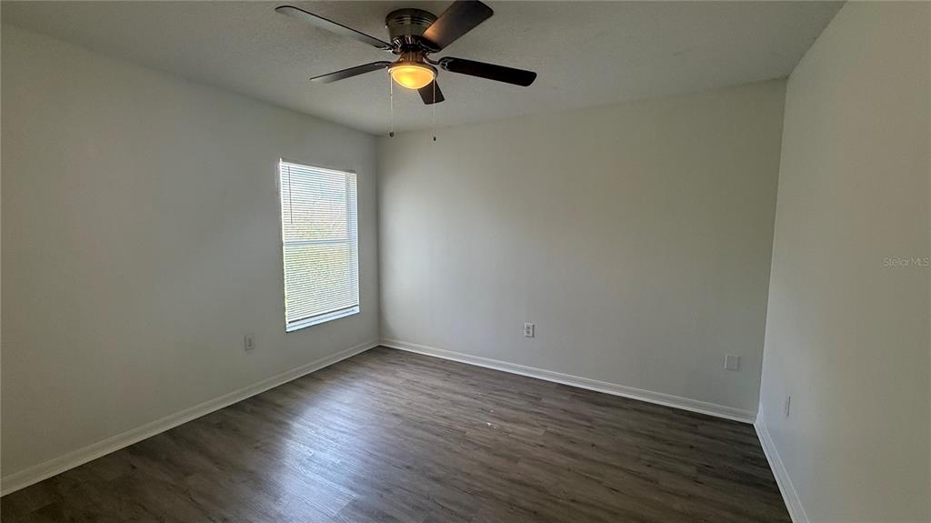 4484 Philadelphia Circle Kissimmee, FL 34746 - Photo 17 of 56 an empty room with wooden floor fan and windows