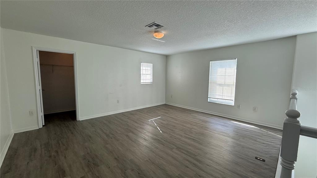 4484 Philadelphia Circle Kissimmee, FL 34746 - Photo 31 of 56 an empty room with wooden floor and windows