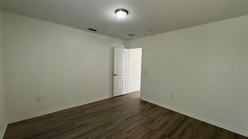 4484 Philadelphia Circle Kissimmee, FL 34746 - Photo 32 of 56 an empty room with wooden floor and windows