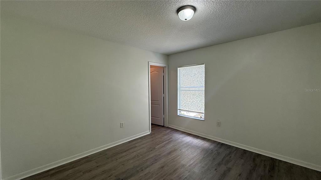 4484 Philadelphia Circle Kissimmee, FL 34746 - Photo 34 of 56 an empty room with wooden floor and windows