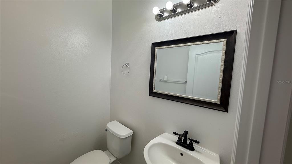 4484 Philadelphia Circle Kissimmee, FL 34746 - Photo 52 of 56 a bathroom with a toilet sink and mirror