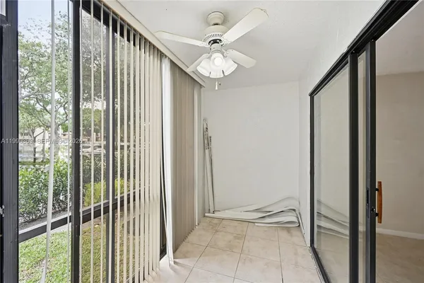 a view of a hallway with a chandelier fan and glass door