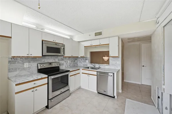 a kitchen with white cabinets stainless steel appliances and a sink