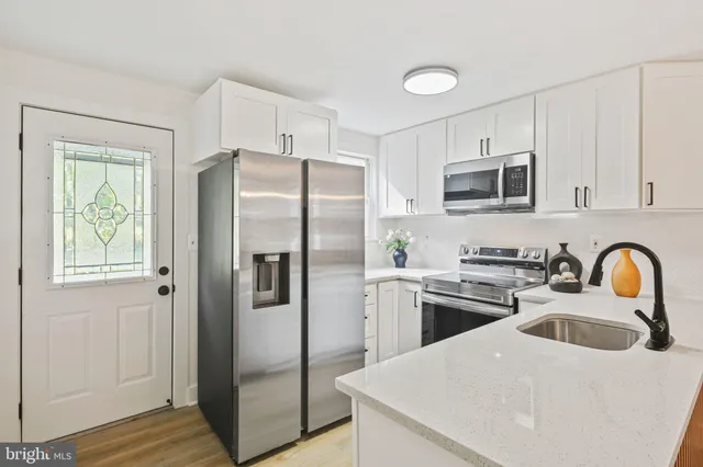a kitchen with stainless steel appliances a refrigerator stove microwave and sink