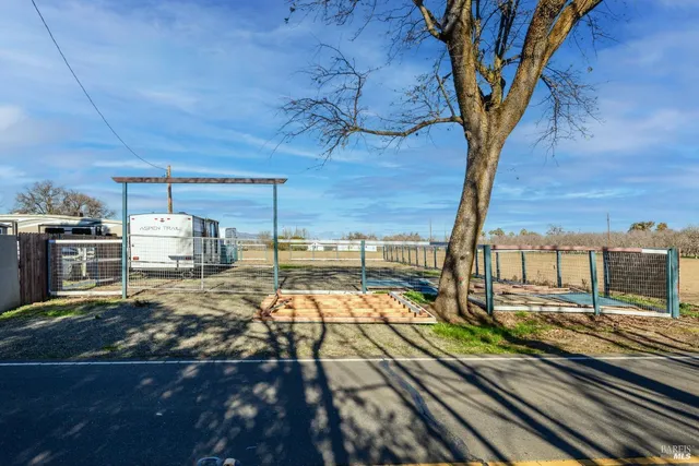 a view of a yard with wooden fence