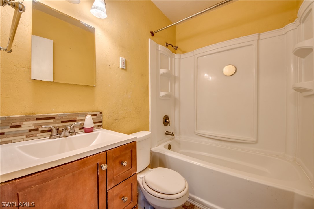 18481 Iris Road Fort Myers, FL 33967 - Photo 22 of 28 a bathroom with a sink a toilet a mirror and shower