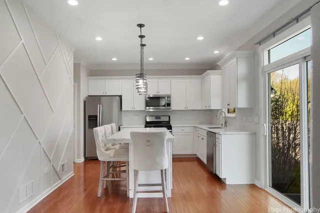 a kitchen with a table chairs refrigerator and microwave