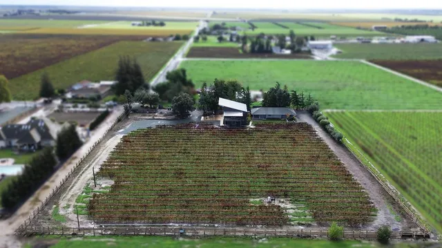 a kitchen with stainless steel appliances granite countertop a sink a stove a refrigerator and island with wooden floor