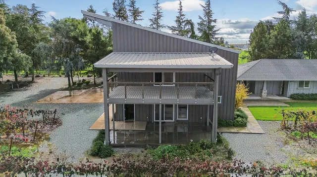 a view of a house with a yard and potted plants