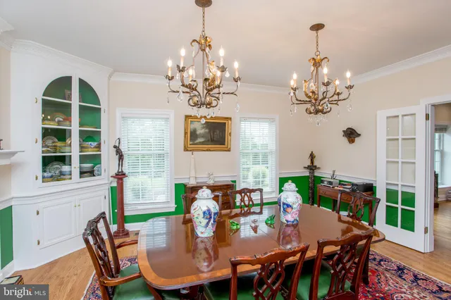 a view of a dining room with furniture a chandelier and wooden floor
