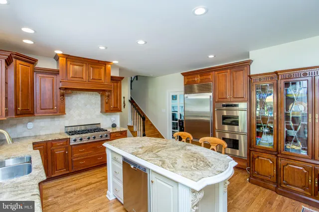 a kitchen with stainless steel appliances granite countertop a sink a stove and a refrigerator