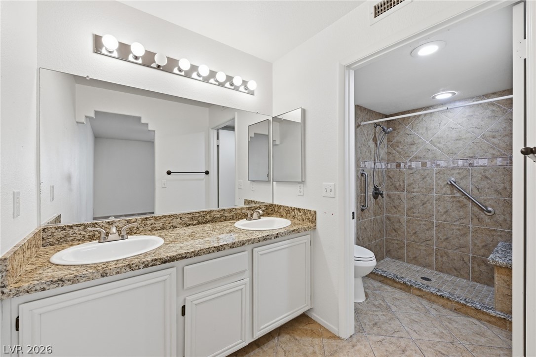 1851 Hillpointe Road, Unit 1311 Henderson, NV 89074 - Photo 21 of 47 Full bath featuring double vanity, a shower stall, and light tile patterned flooring