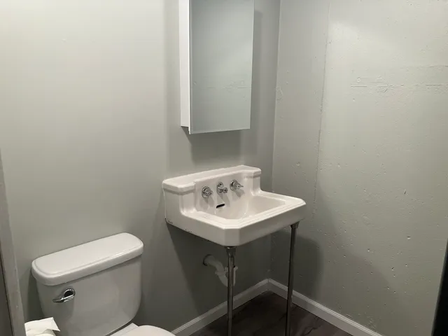 a bathroom with a sink a toilet and a mirror