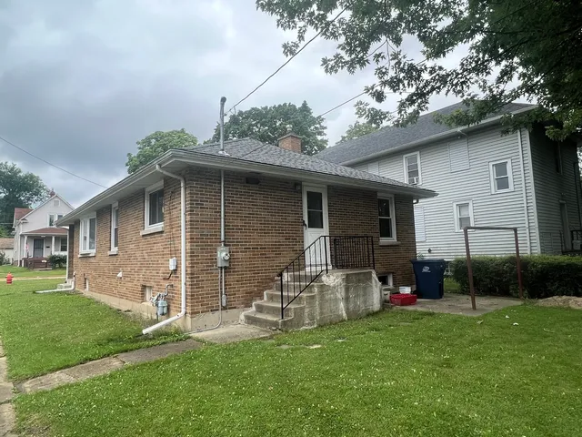 a backyard of a house with table and chairs