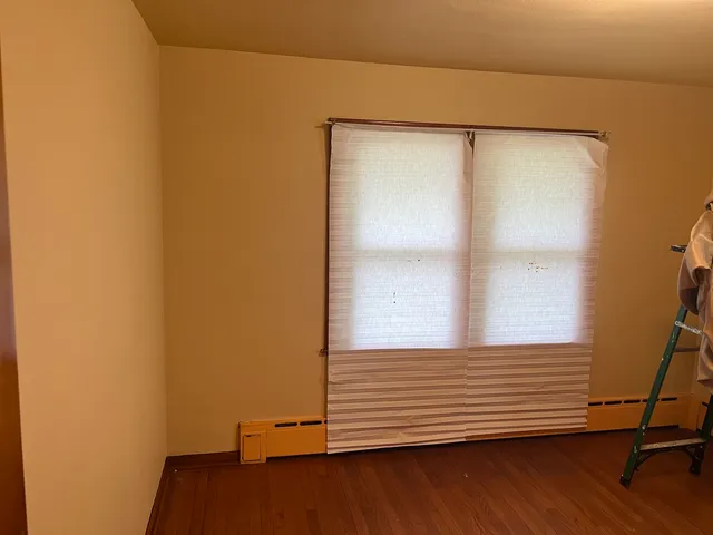 a view of a small space with wooden floor and a window
