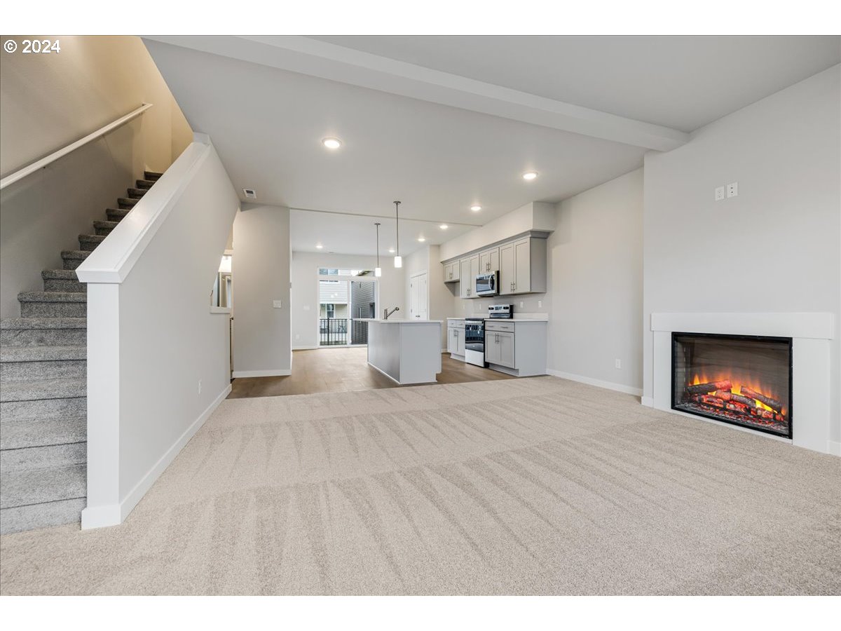 1485 North Chehalis Lane Newberg, OR 97132 - Photo 11 of 38 a view of an empty room and a kitchen with a fireplace