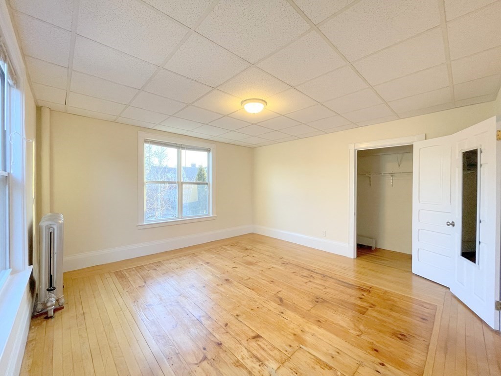 16 Dayton Street, Unit 2F Worcester, MA 01609 - Photo 6 of 21 a view of an empty room with wooden floor and a window