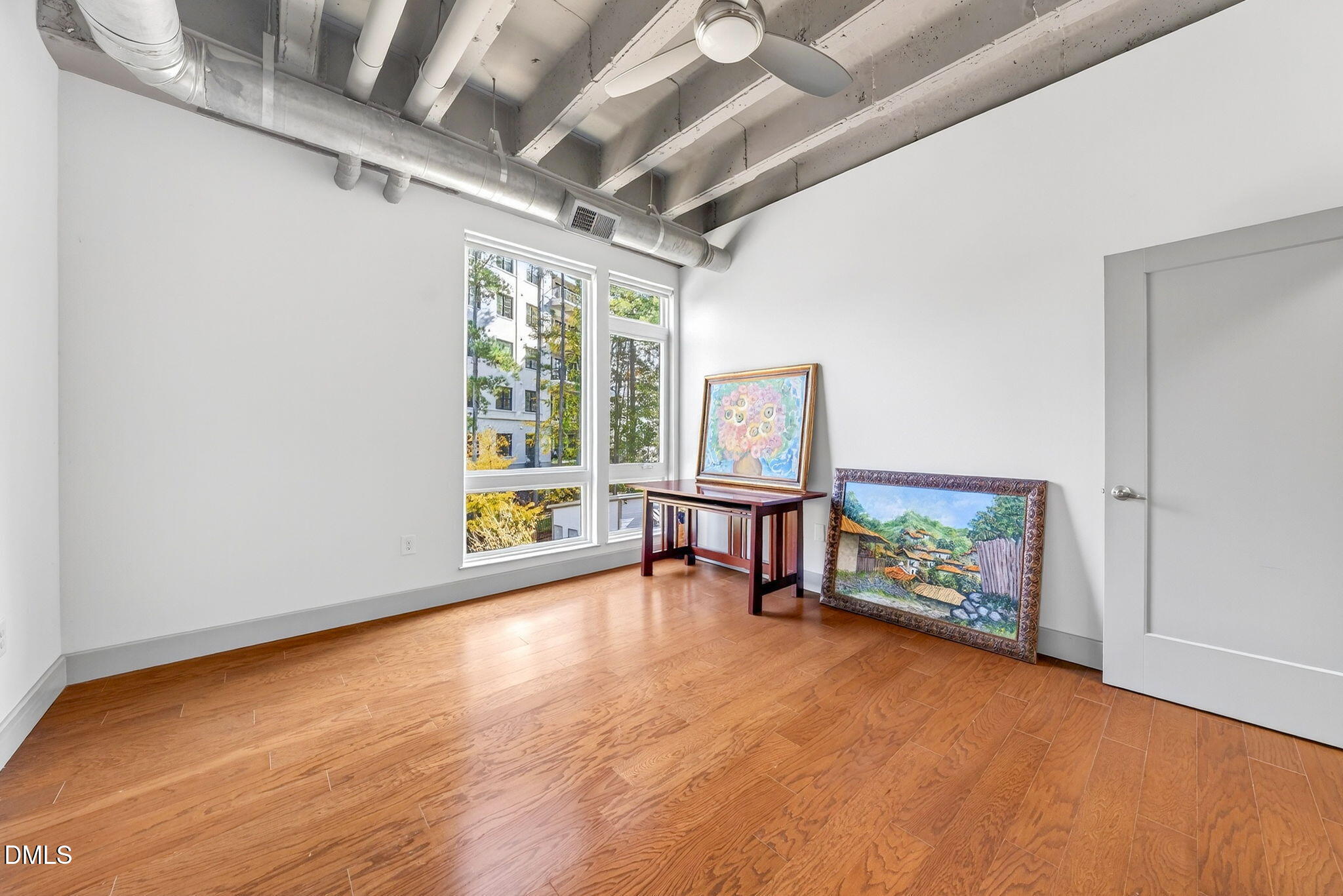 1300 St Marys Street, Unit 203 Raleigh, NC 27605 - Photo 19 of 24 a view of an empty room with window and wooden floor