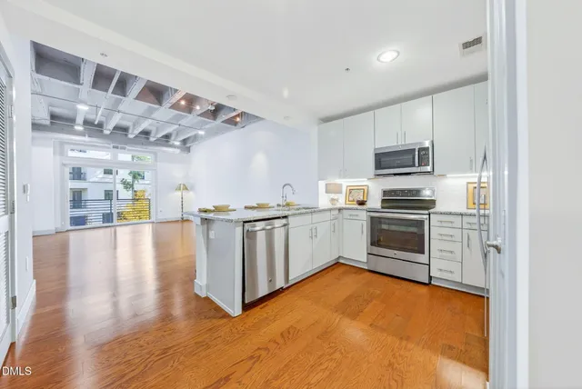 a kitchen with a refrigerator sink and white cabinets