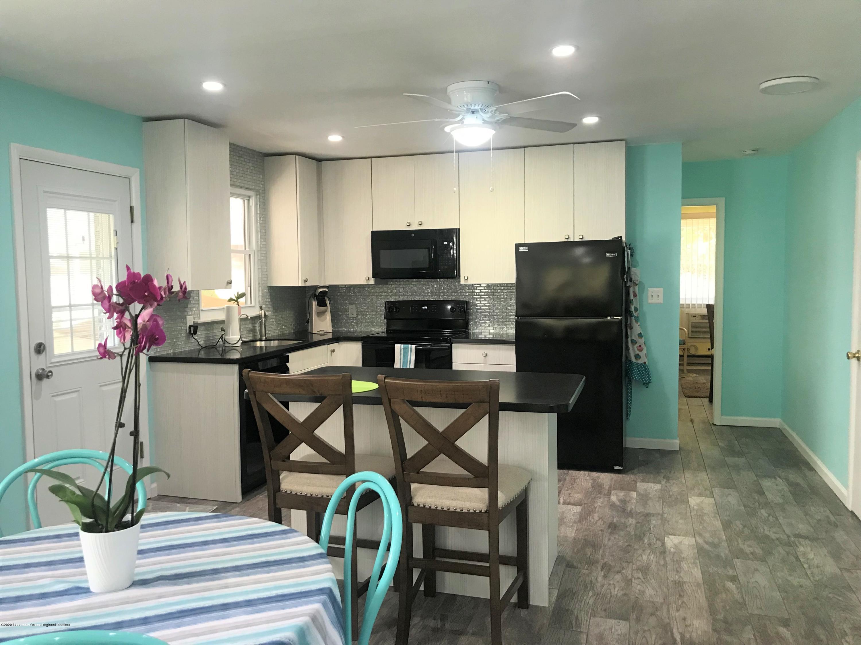 40 A Sunset Road Whiting, NJ 08759 - Photo 7 of 17 a kitchen with stainless steel appliances kitchen island granite countertop a refrigerator a stove a microwave oven a sink with a dining table and chairs