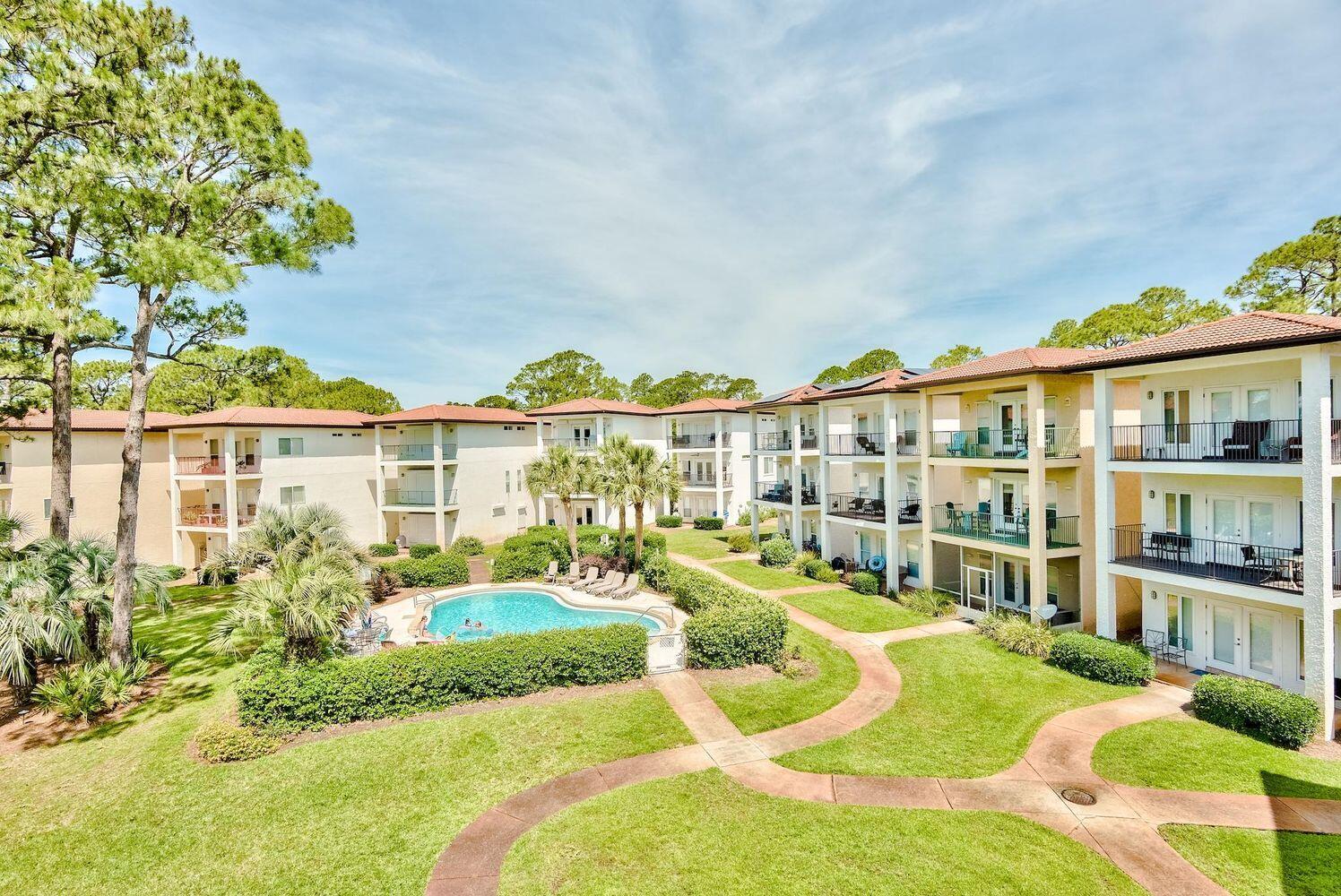 114 Mar-A-Lago Boulevard, Unit 1 Santa Rosa Beach, FL 32459 - Photo 11 of 28 a view of a white building with a swimming pool and outdoor seating