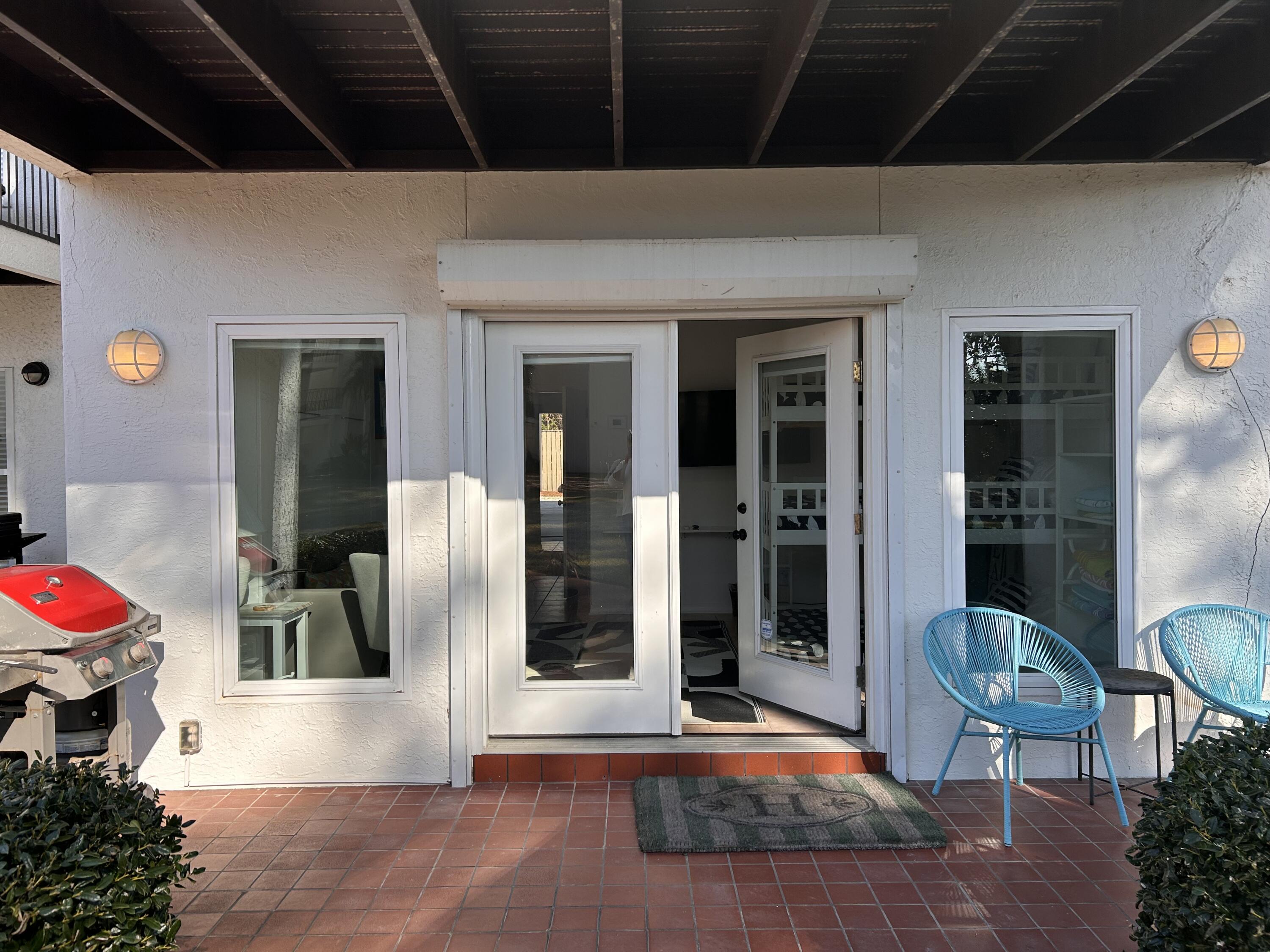 114 Mar-A-Lago Boulevard, Unit 1 Santa Rosa Beach, FL 32459 - Photo 33 of 49 a view of a porch with a table and chairs and potted plants