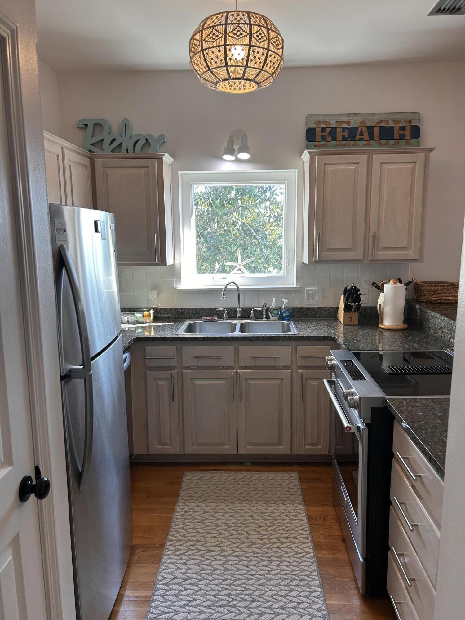 114 Mar-A-Lago Boulevard, Unit 1 Santa Rosa Beach, FL 32459 - Photo 36 of 49 a kitchen with granite countertop a refrigerator a sink a stove a washer and dryer