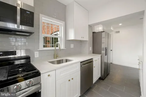 a kitchen with stainless steel appliances granite countertop a sink and a stove