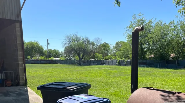 a view of a big yard with swimming pool and patio