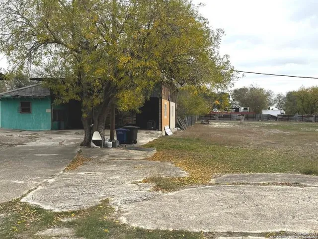 a view of a yard with a house and a tree
