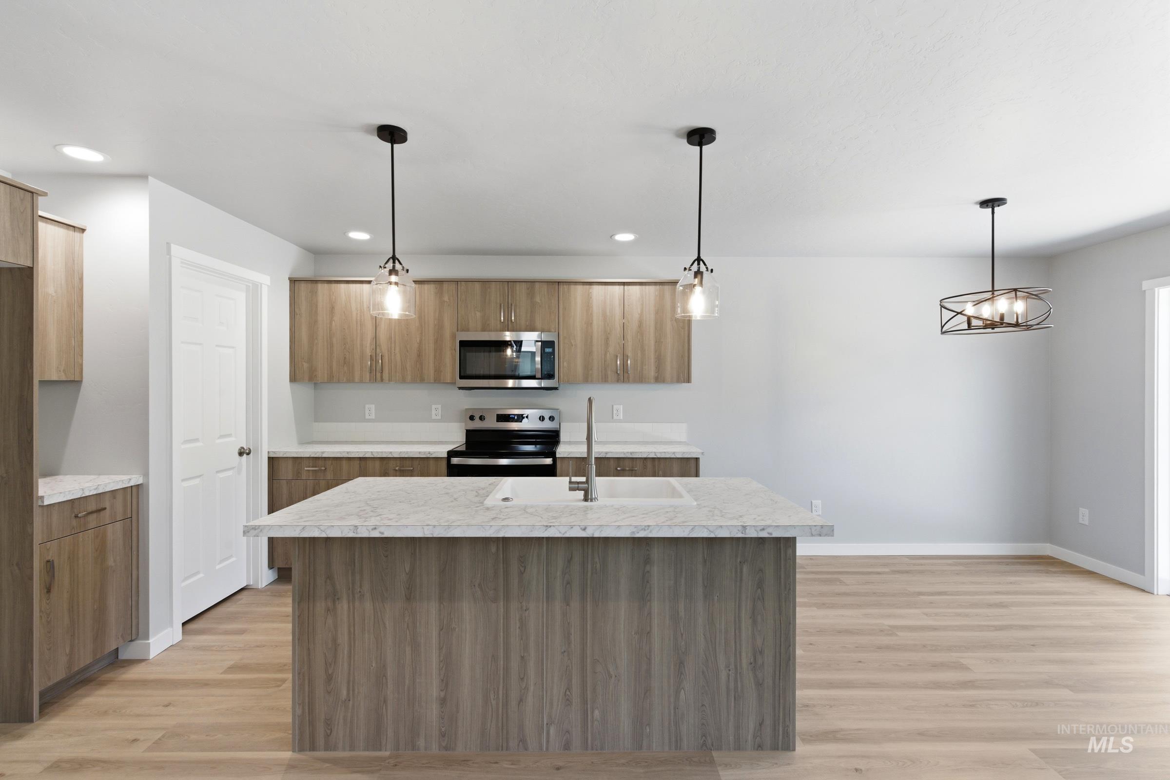 2374 West Fallon Loop Nampa, ID 83651 - Photo 3 of 24 Modern kitchen featuring a central island with an undermount sink and light-toned countertop