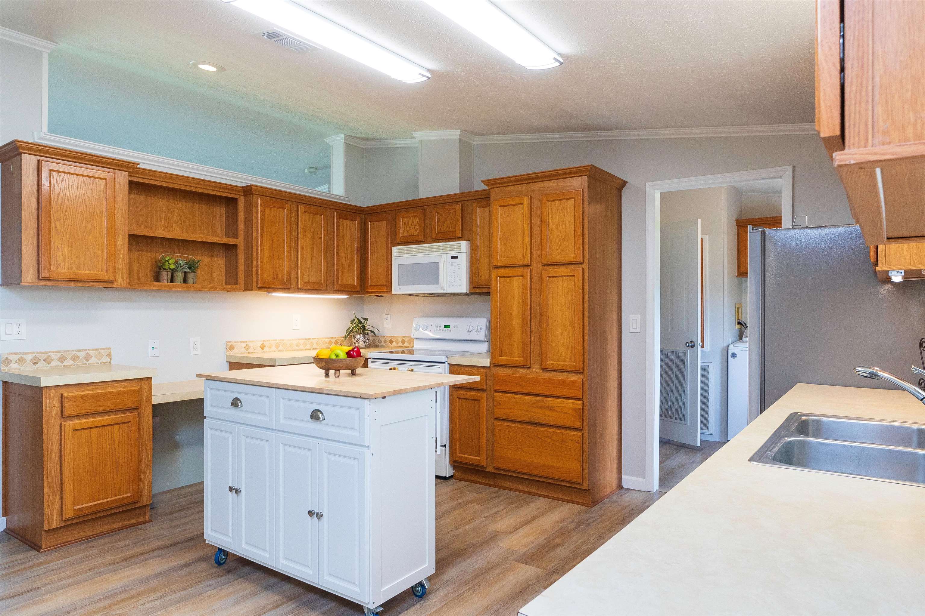 2232 Whippoorwill Drive St. Augustine, FL 32084 - Photo 10 of 51 a kitchen with stainless steel appliances granite countertop a refrigerator a sink dishwasher and white cabinets with wooden floor