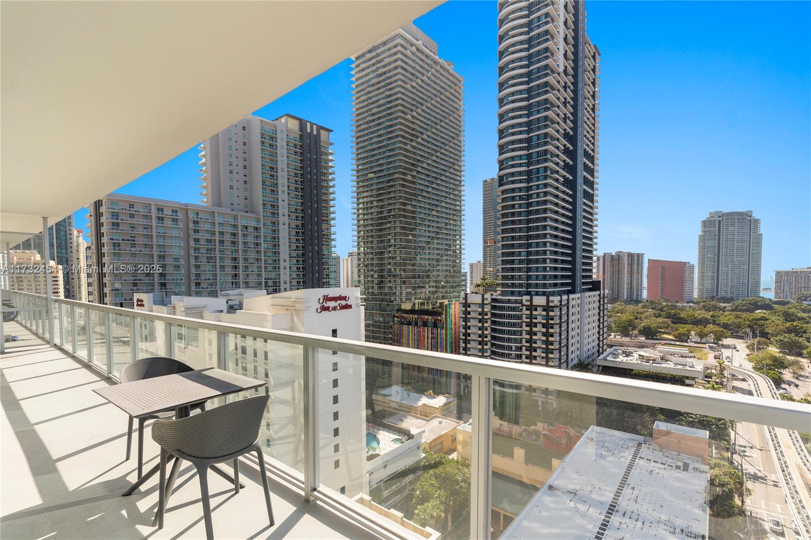 79 Southwest 12th Street, Unit 2001S Miami, FL 33130 - Photo 14 of 29 a view of a balcony with two chairs and a wooden floor