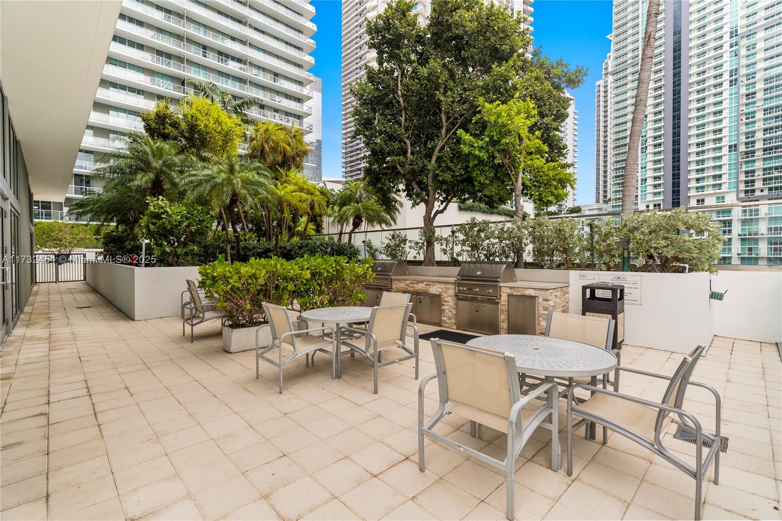 79 Southwest 12th Street, Unit 2001S Miami, FL 33130 - Photo 27 of 29 a view of a patio with a dining table and chairs with potted plants and a fountain