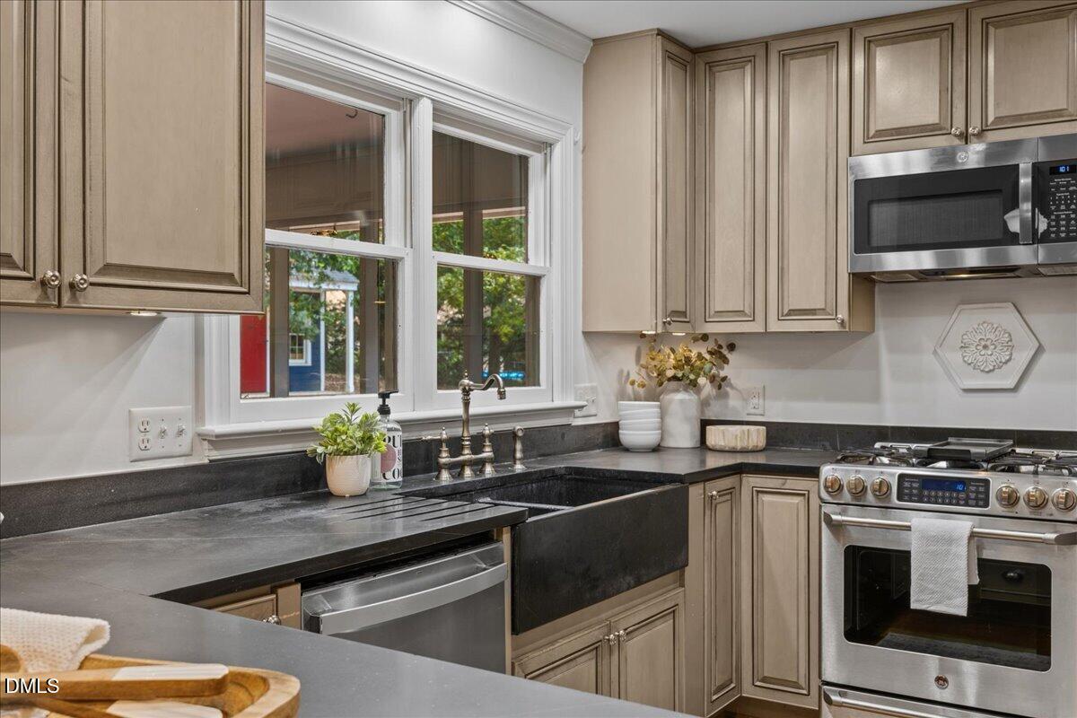 6516 Bakersfield Drive Raleigh, NC 27606 - Photo 22 of 59 a kitchen with stainless steel appliances a stove a sink and a microwave