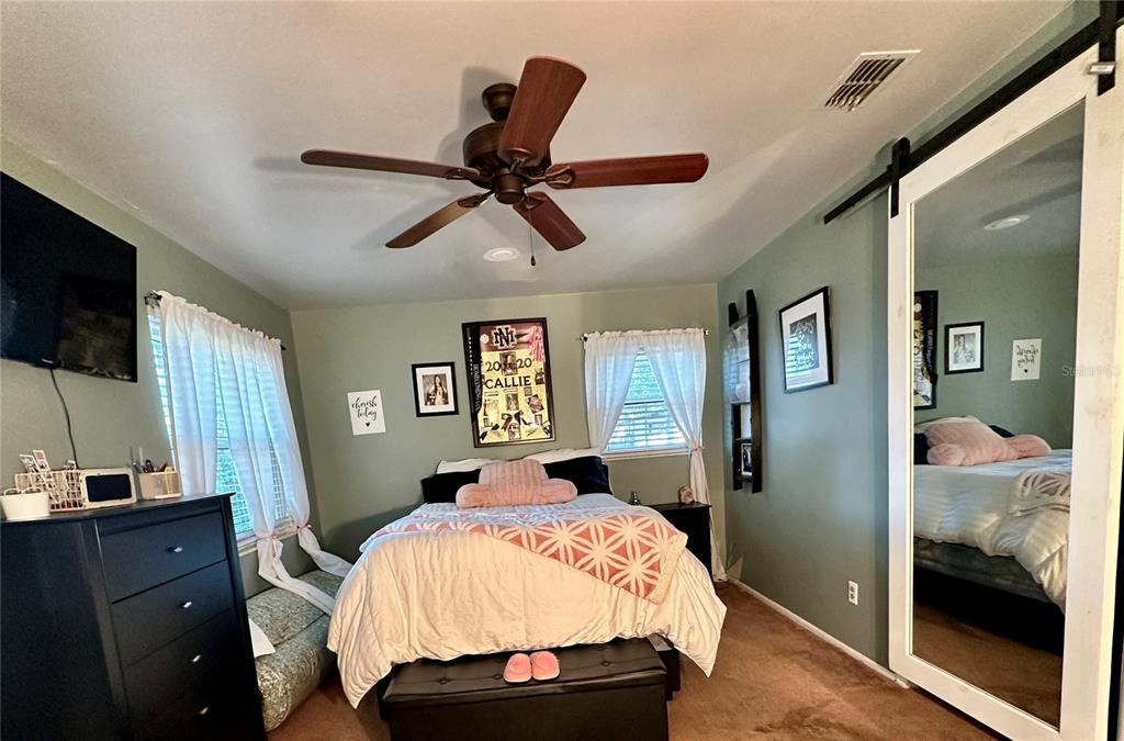 13565 Northeast 38th Avenue Anthony, FL 32617 - Photo 19 of 39 a bedroom with a bed and a flat screen tv