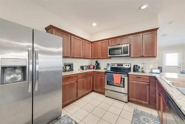 a kitchen with stainless steel appliances granite countertop a refrigerator stove and a sink