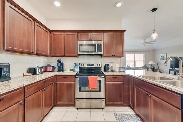 a kitchen with stainless steel appliances granite countertop wooden cabinets a sink and dishwasher