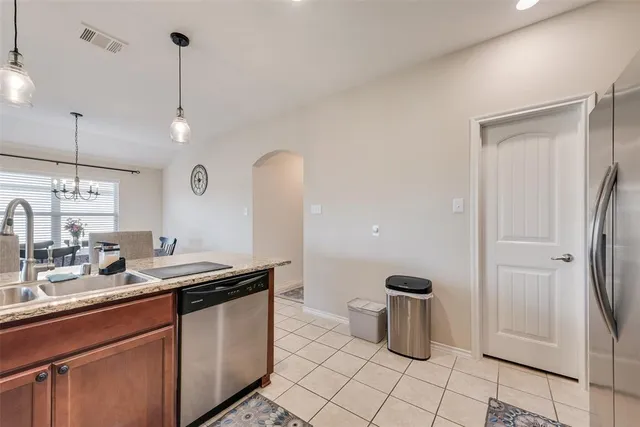 a kitchen with stainless steel appliances granite countertop a sink and a refrigerator