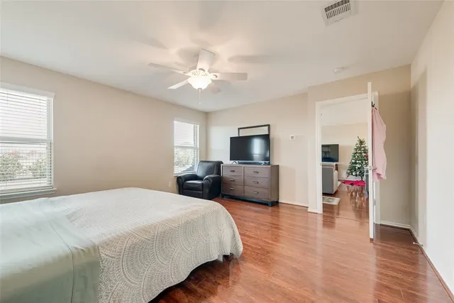 a bedroom with a bed flat screen tv and couches