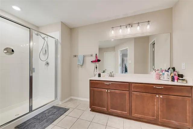 a bathroom with a sink mirror and shower