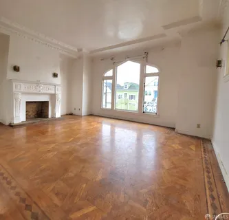 wooden floor fireplace and windows in an empty room