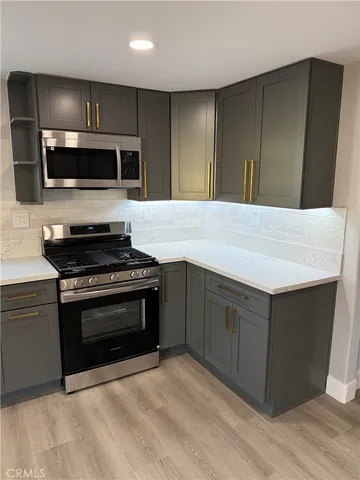 a kitchen with stainless steel appliances granite countertop a stove and a microwave