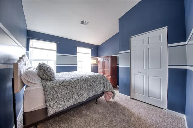 a living room with a bed and a refrigerator